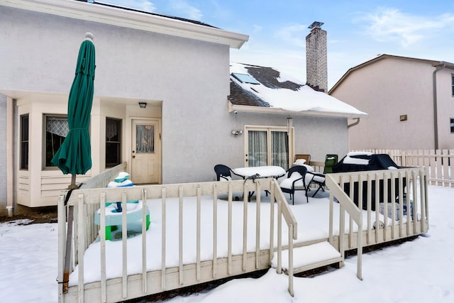 snow covered house with a deck