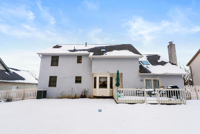 snow covered property featuring cooling unit and a deck