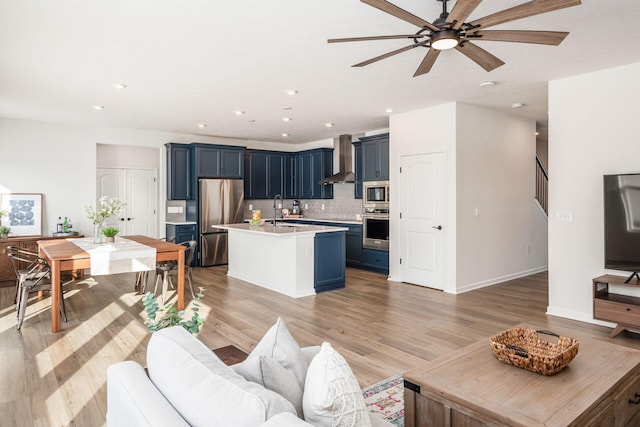 living room featuring sink, ceiling fan, and light hardwood / wood-style flooring