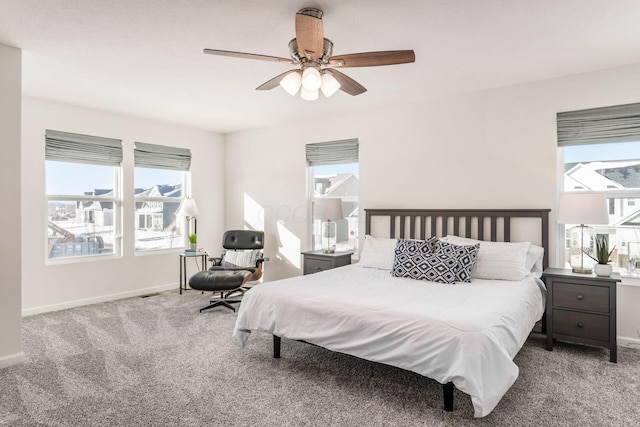 carpeted bedroom with ceiling fan and multiple windows