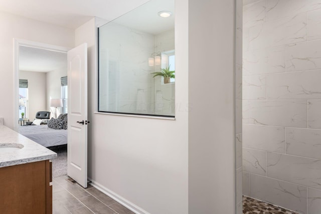 bathroom with tiled shower and vanity