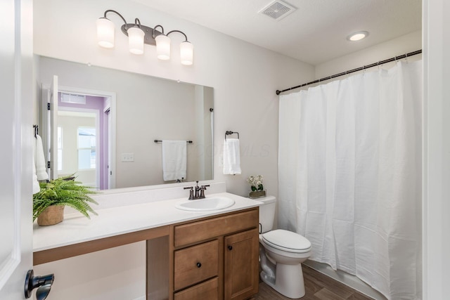 bathroom with toilet, vanity, and hardwood / wood-style flooring