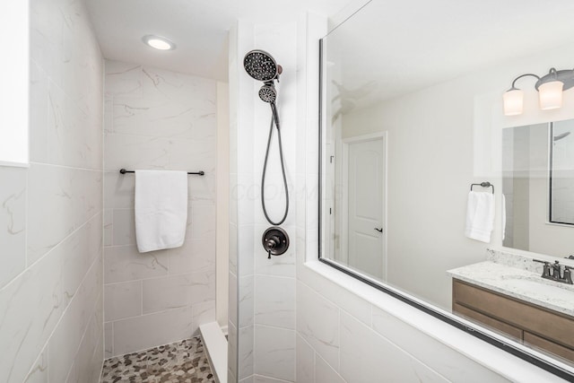 bathroom featuring a tile shower and vanity