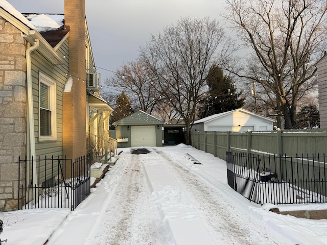 view of snowy exterior with a garage and an outdoor structure