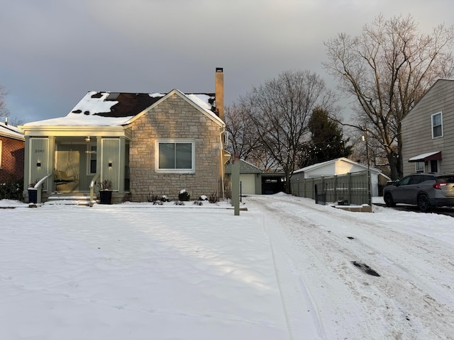 view of front of home with a garage and an outbuilding