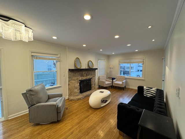 living room featuring a fireplace, wood-type flooring, a wealth of natural light, and ornamental molding