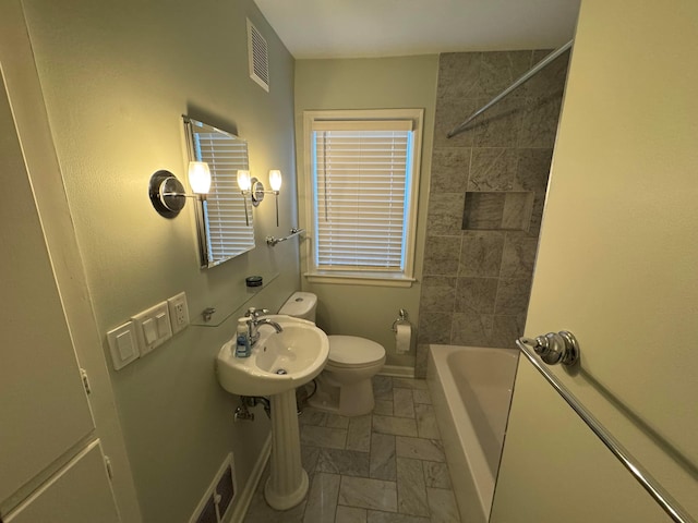 full bathroom with sink, tiled shower / bath, and toilet