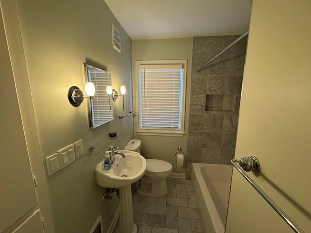 full bathroom with toilet, sink, and tiled shower / bath