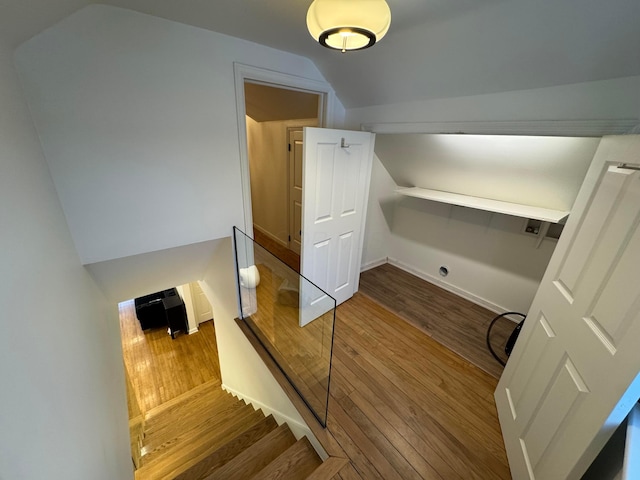 stairway with lofted ceiling and hardwood / wood-style flooring