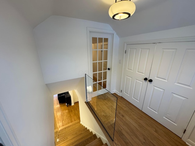 staircase with hardwood / wood-style flooring and vaulted ceiling