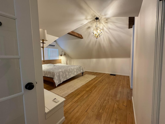 unfurnished bedroom with vaulted ceiling with beams, light hardwood / wood-style floors, and a chandelier