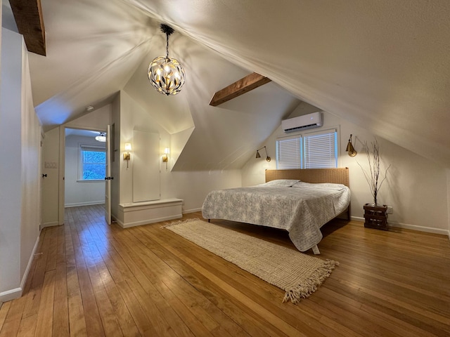 bedroom featuring lofted ceiling with beams, hardwood / wood-style flooring, an inviting chandelier, and a wall mounted AC