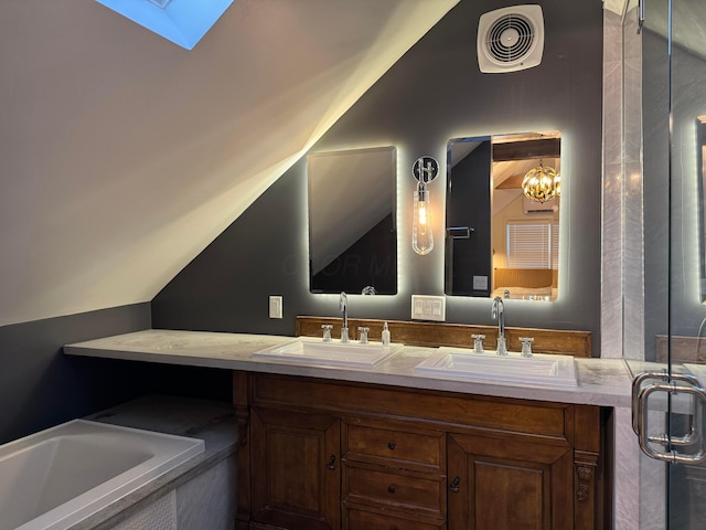 bathroom featuring vaulted ceiling with skylight and vanity