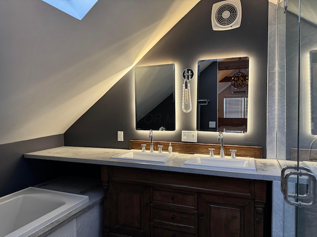 bathroom with vaulted ceiling with skylight and vanity