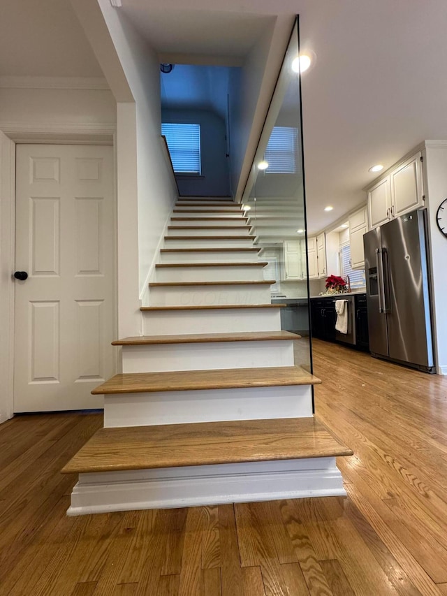 stairway featuring hardwood / wood-style flooring and crown molding