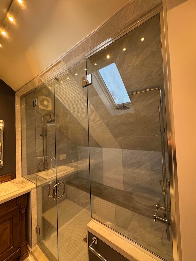 bathroom with vanity, an enclosed shower, and a skylight