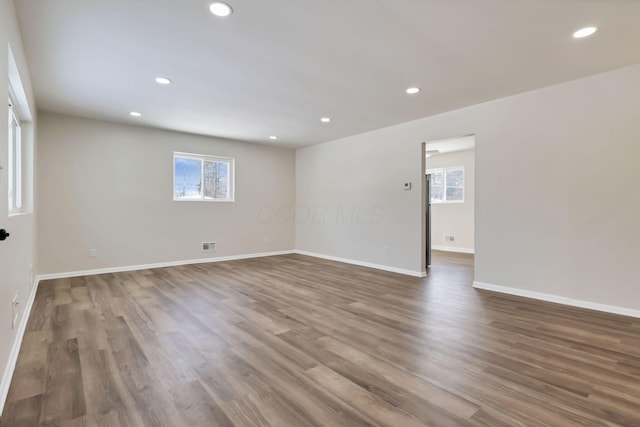 empty room featuring a wealth of natural light and hardwood / wood-style floors