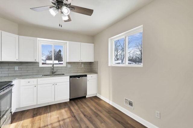 kitchen with tasteful backsplash, stainless steel dishwasher, sink, electric range, and white cabinetry