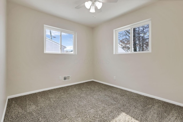 carpeted spare room featuring ceiling fan