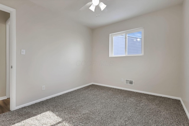 spare room featuring ceiling fan and dark carpet