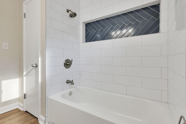 bathroom with tiled shower / bath combo and wood-type flooring