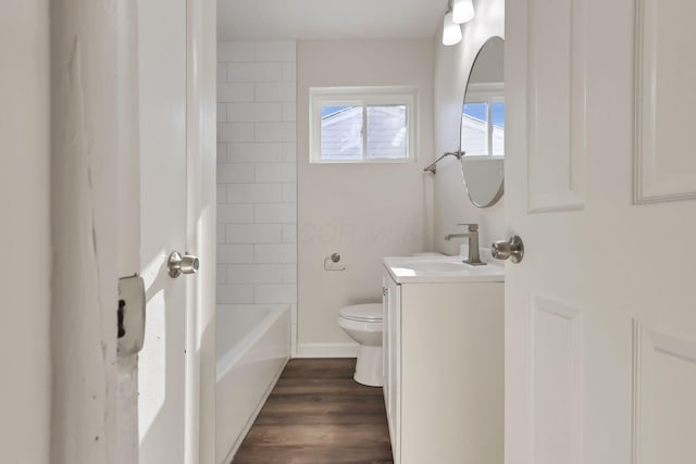 full bathroom featuring tiled shower / bath, vanity, wood-type flooring, and toilet