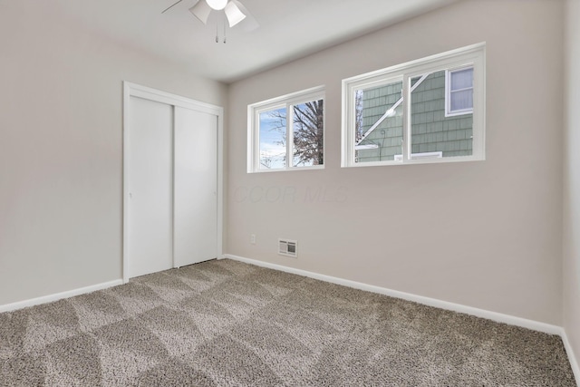 unfurnished bedroom with ceiling fan, a closet, and carpet floors