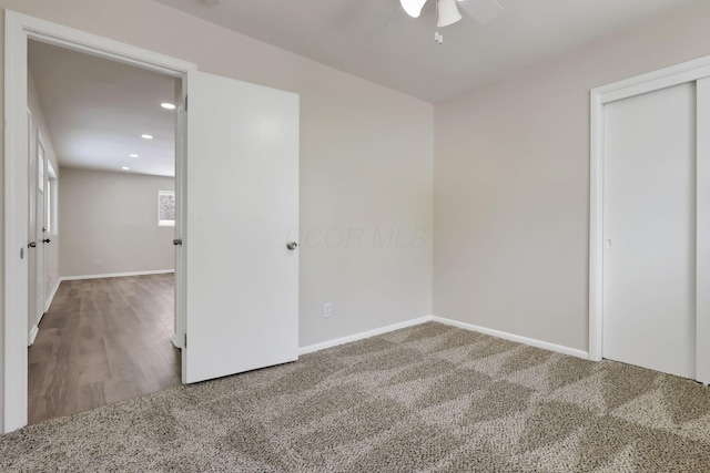 unfurnished bedroom featuring carpet, ceiling fan, and a closet