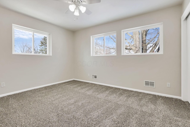 carpeted spare room featuring ceiling fan