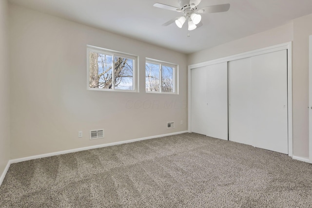 unfurnished bedroom featuring carpet flooring, ceiling fan, and a closet