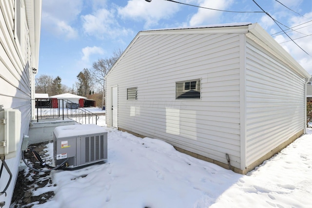 snow covered property with central AC unit