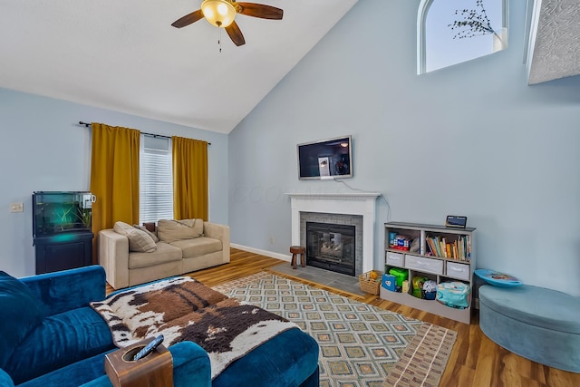 living room with a fireplace, hardwood / wood-style flooring, high vaulted ceiling, and ceiling fan