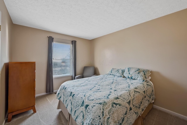 bedroom featuring a textured ceiling and light carpet