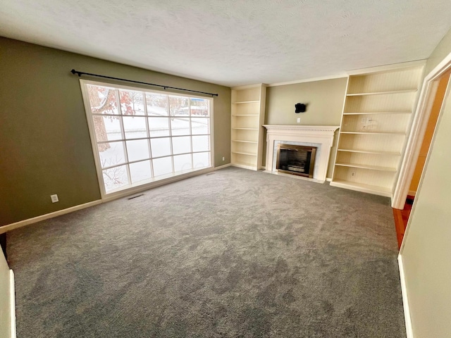 unfurnished living room with dark colored carpet and a textured ceiling