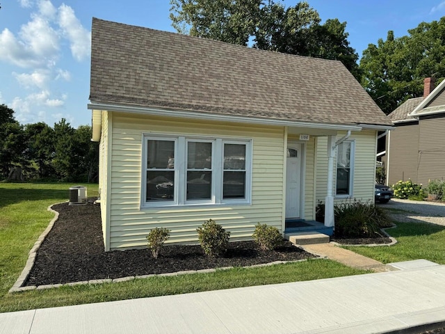 view of front of home featuring cooling unit and a front yard