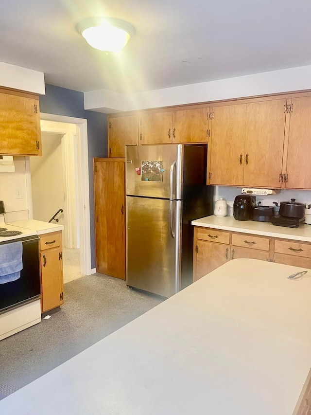 kitchen featuring white electric range oven and stainless steel fridge