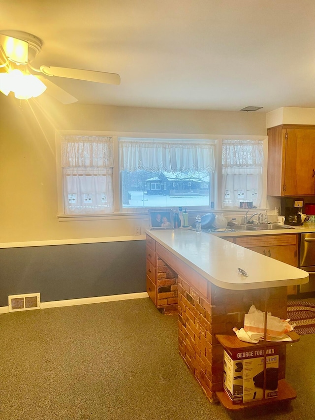 kitchen featuring carpet flooring, ceiling fan, kitchen peninsula, and sink