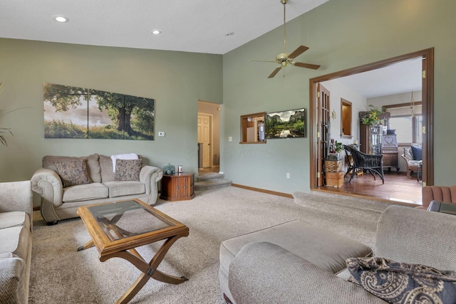 carpeted living room with vaulted ceiling and ceiling fan