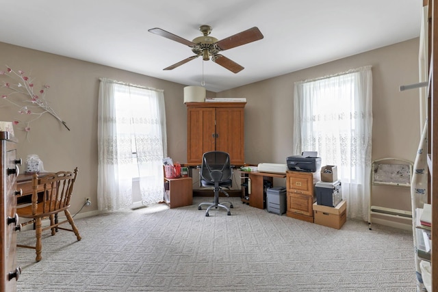 carpeted home office featuring ceiling fan