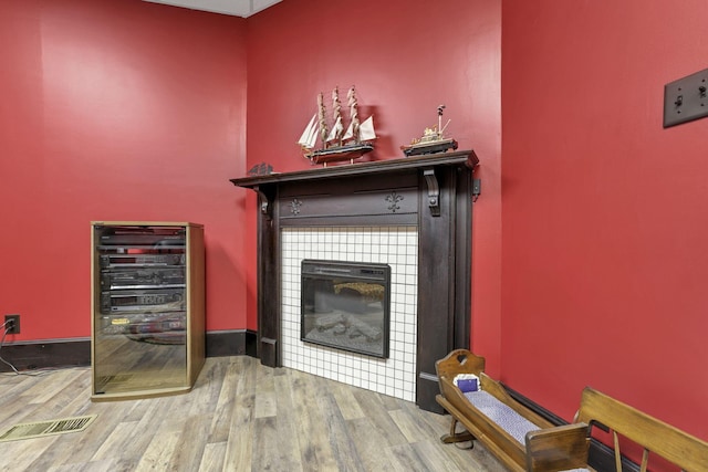 room details featuring a tile fireplace, hardwood / wood-style floors, and wine cooler