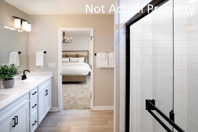 bathroom with walk in shower, vanity, a notable chandelier, and hardwood / wood-style floors