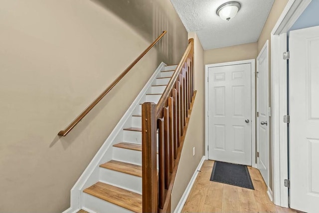 staircase featuring hardwood / wood-style flooring and a textured ceiling