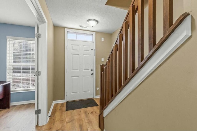 entrance foyer featuring a textured ceiling and light wood-type flooring