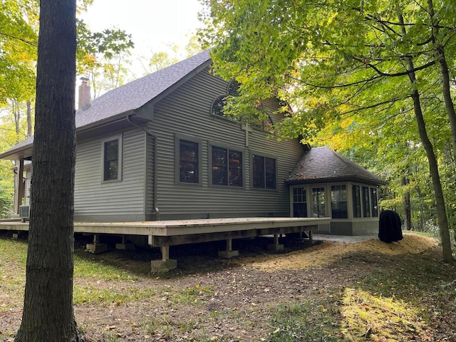 view of side of property featuring a deck and a sunroom