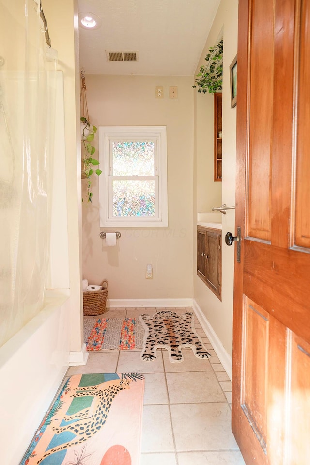 bathroom with tile patterned flooring, vanity, and shower / bath combo with shower curtain