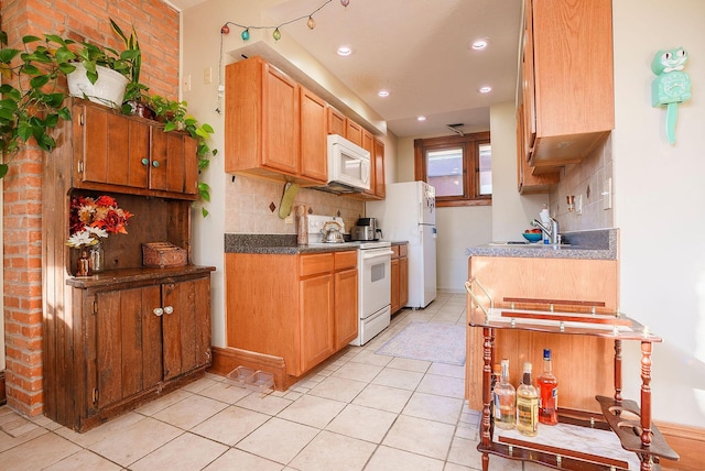 kitchen featuring light tile patterned flooring, white appliances, sink, and tasteful backsplash