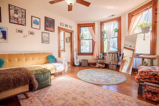 sitting room with ceiling fan, a textured ceiling, and hardwood / wood-style flooring