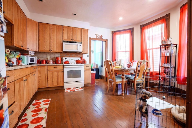 kitchen featuring tasteful backsplash, dark hardwood / wood-style floors, and white appliances