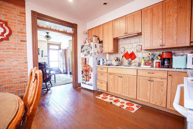 kitchen featuring tasteful backsplash, ceiling fan, white fridge, and dark wood-type flooring