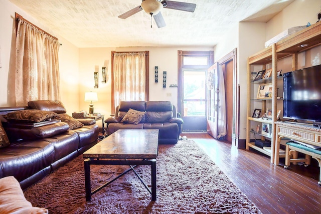 living room featuring wood-type flooring, a textured ceiling, and ceiling fan